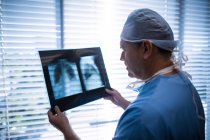 Cirurgião masculino examinando raio-X no hospital — Fotografia de Stock