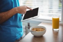 Mittelteil des Menschen nutzt sein digitales Tablet zu Hause in der Küche — Stockfoto