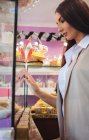 Schöne Frau betrachtet türkische Süßigkeiten, die im Geschäft ausgestellt sind — Stockfoto