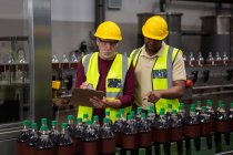 Чоловіки-робітники обговорюють на заводі соків — стокове фото