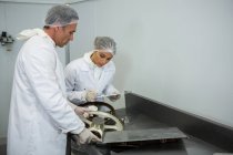 Techniker halten Rekord auf Klemmbrett in Fleischfabrik — Stockfoto