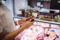 Mulher olhando para garrafa no supermercado — Fotografia de Stock