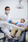 Портрет стоматолога, лечащего пациентку в клинике — стоковое фото