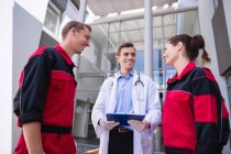 Médico falando com paramédico no corredor do hospital — Fotografia de Stock