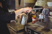Camarera usando la máquina de café en la cafetería - foto de stock