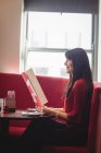 Жінка тримає меню в кріслі ресторану — стокове фото