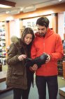 Couple sélectionnant la chaussure ensemble dans un magasin — Photo de stock