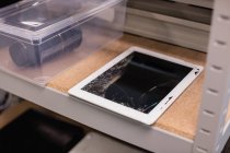 Tableta digital dañada en un centro de reparación - foto de stock