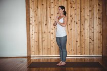 Femme adulte moyenne effectuant du yoga dans un studio de fitness — Photo de stock