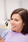 Жіночий пацієнт, який приймає лікування зубів у стоматологічній клініці — стокове фото