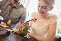 Красивая женщина с суши в ресторане — стоковое фото