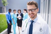 Портрет усміхненого лікаря, що стоїть у лікарняних приміщеннях — стокове фото