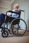 Nachdenklicher Senior sitzt zu Hause im Rollstuhl — Stockfoto