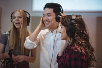 Singers with headphones performing in recording studio — Stock Photo
