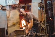 Glassblower shaping a molten glass at glassblowing factory — Stock Photo