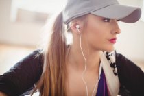 Primer plano de la mujer bonita escuchando los auriculares en el estudio - foto de stock