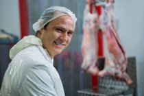 Retrato de açougueiro sorridente na fábrica de carne — Fotografia de Stock