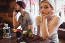 Мужчина игнорирует женщину, разговаривая по телефону в ресторане — стоковое фото