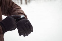 Mi-section de l'homme en utilisant la montre intelligente pendant l'hiver — Photo de stock