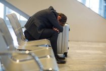 Бизнесмен отдыхает в зоне ожидания в терминале аэропорта — стоковое фото