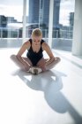 Балерина выполняет упражнения на растяжку в балетной студии — стоковое фото