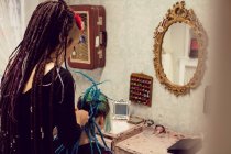 Esteticista peinado clientes cabello en dreadlocks tienda - foto de stock