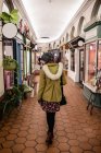 Вид сзади на женщину, идущую в интерьере рынка — стоковое фото