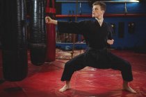 Молодий дорослий карате гравець виконує позицію карате в фітнес-студії — стокове фото