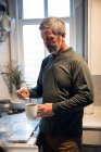 Mann bereitet in Küche zu Hause einen schwarzen Kaffee zu — Stockfoto