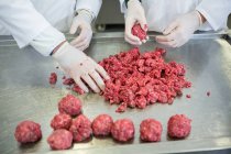 Corte médio de açougueiros preparando bolas de carne na fábrica de carne — Fotografia de Stock