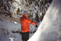 Uomo ascoltare musica in cuffia da smartphone durante l'inverno — Foto stock