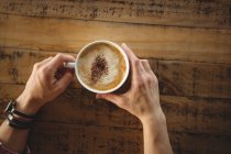 Mains de femme tenant une tasse de café dans un café — Photo de stock