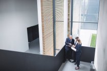 Group of business people having a discussion near staircase in office — Stock Photo
