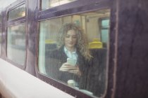 Mujer de negocios rubia usando smartphone mientras viaja - foto de stock
