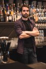 Retrato de um barman confiante em pé no balcão do bar — Fotografia de Stock