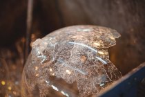Close-up of waste glass in a metal container at glassblowing factory — Stock Photo