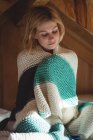Bella donna avvolta in una coperta di lana in camera da letto a casa — Foto stock