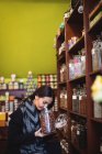 Belle femme sentant pot d'épices dans la boutique — Photo de stock