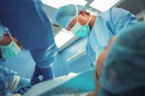 Team of surgeons performing operation in operation theater at hospital — Stock Photo
