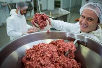 Metzger legt Fleisch in Fleischwolf in Fleischfabrik — Stockfoto
