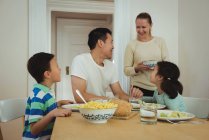 Happy family having meal at home — Stock Photo