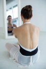 Ballerina sitting in front of mirror in ballet studio — Stock Photo
