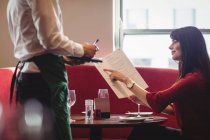 Cameriere prendere ordine da donna in un ristorante — Foto stock