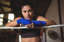 Portrait of female boxer standing in boxing ring — Stock Photo