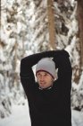 Продуманий людина розтягування зброї в лісі під час зими — стокове фото
