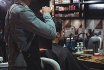 Barbeiro mostrando homem corte de cabelo no espelho na barbearia — Fotografia de Stock