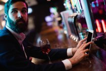 Geschäftsmann nutzt digitales Tablet mit Weinglas auf Theke in Bar — Stockfoto