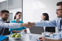 Doctors shaking hands with each other in meeting at conference room — Stock Photo