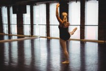 Ballerina performing ballet dance move in ballet studio — Stock Photo