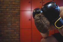 Наголошений боксер сидить з боксерськими рукавичками в роздягальні — стокове фото